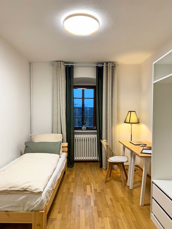 Einzelzimmer mit Schreibtisch und Kleiderschrank